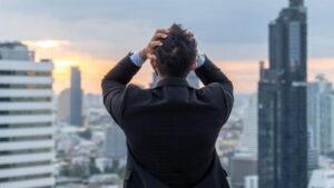 Imprenditore in piedi sul tetto di un edificio in città dopo il lavoro