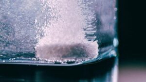 Tablet in vetro con acqua su uno sfondo nero
