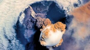 Eruzione vulcanica vista dallo spazio, che mostra una enorme macchia bianca che esce da un cratere