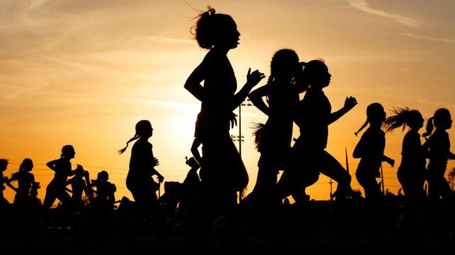Silhouette di molte persone che corrono al tramonto