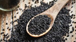 semi di cumino nero su un cucchiaio di legno
