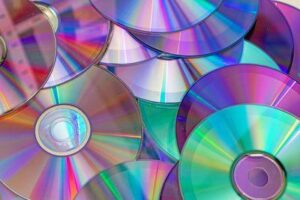 Un mucchio di CD, dischi compatti, che mostrano la loro lucentezza.