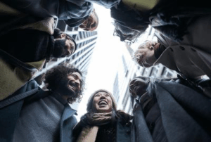 Un gruppo di persone in piedi in un cerchio, immaginato dal basso.