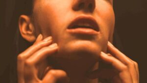 donna che si tocca il viso