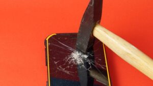 Martello che rompe lo schermo di un telefono cellulare