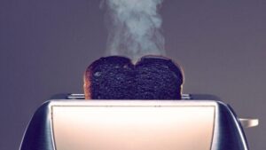 Tostapane con una fetta di toast bruciato e fumante