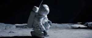 Un'astronauta femmina in ginocchio sulla superficie della Luna.