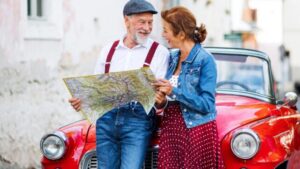 uomo e donna con una mappa vicino a un'auto
