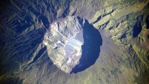 Questa dettagliata fotografia di astronauta ritrae la caldera sommitale del vulcano Tambora. La enorme caldera ha un diametro di 6 chilometri e una profondità di 1.100 metri, formata quando il picco stimato di 4.000 metri di altezza di Tambora è stato rimosso e la camera magmatica sottostante si è svuotata durante l'eruzione del 1815.