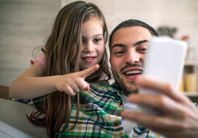 genitore e bambino che guardano il loro telefono