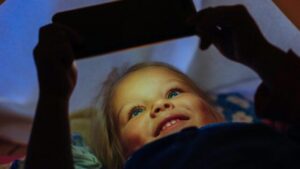 ragazza sdraiata, che guarda un telefono