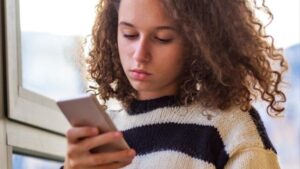 adolescente con un cellulare