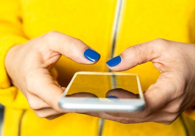persona con una giacca gialla che tiene un telefono