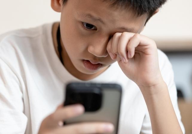 bambino stanco con un telefono