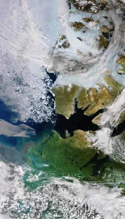 Immagine satellitare delle isole artiche, che mostra nuvole, ghiaccio marino e fumi di incendi boschivi.