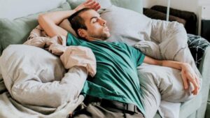Un giovane sul divano in una posizione seduta scomoda