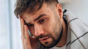 Uomo malato a casa, sembra avere un forte mal di testa