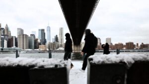 Persone che camminano sotto un ponte in un tempo nevoso