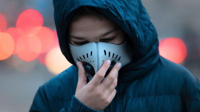 Giovane che indossa una maschera in un'area ad alta densità di traffico