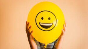 Persona irriconoscibile che tiene un palloncino giallo