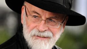 Terry Pratchett che indossa un cappello a cilindro nero, che guarda a sinistra del fotogramma
