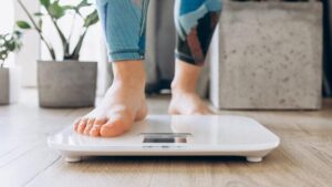 Primo piano di piedi nudi che poggiano su una bilancia digitale