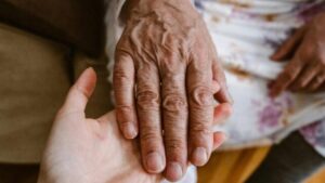 la mano di una persona anziana tenuta da una persona più giovane