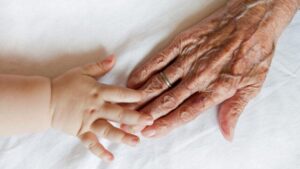 la mano di un bambino che tocca una mano più anziana