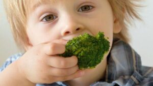 Bambino che mangia broccoli