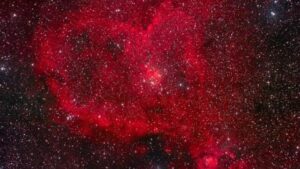 Un oggetto rosso a forma di cuore in un cielo stellato