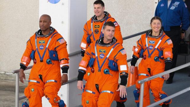 Quattro astronauti della NASA che escono da un edificio