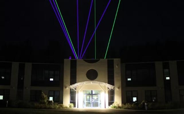 laser che emergono dalla cima di un edificio di notte