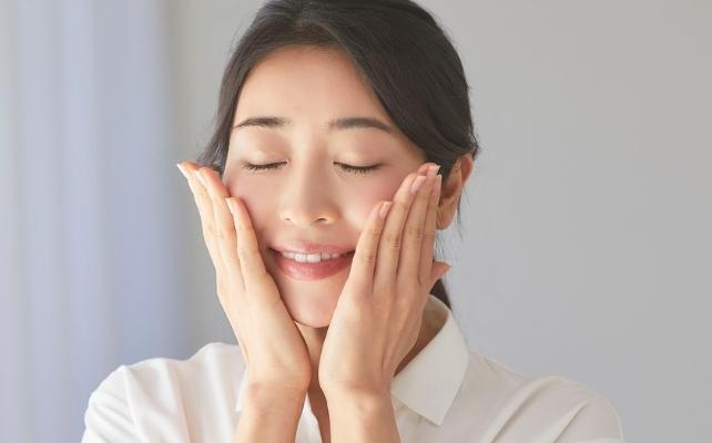 donna che si tocca il viso con gli occhi chiusi