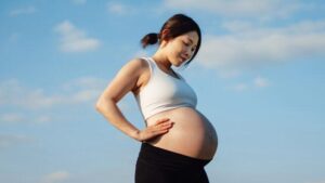 Ritratto di una donna asiatica incinta che si rilassa nel parco