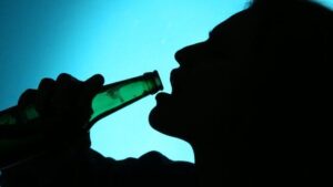 Silhouette di una persona che beve da una bottiglia