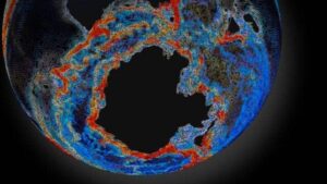 Una sfera scura che rappresenta la Terra, mostrando aree blu, rosse e grigie per descrivere la corrente circumpolare antartica