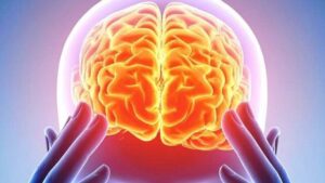 Illustrazione computerizzata di un cervello umano luminoso all'interno di una testa, con le punte delle dita che premono sui bordi