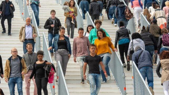Le persone salgono e scendono le scale in uno spazio pubblico urbano affollato