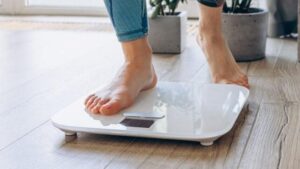Primo piano di piedi nudi che poggiano su una bilancia digitale