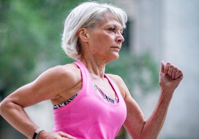 Donna anziana che corre all'aperto