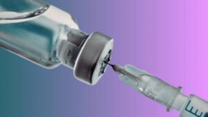 Immagine ravvicinata di un flacone capovolto con una siringa medica che estrae liquido da esso
