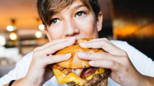 l'adolescente mangia un hamburger