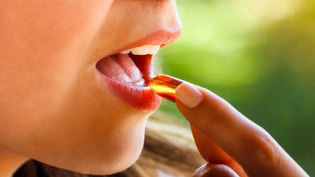 Hand-placing-supplement-into-mouth-backlit-by-sun-642x361-1.jpg