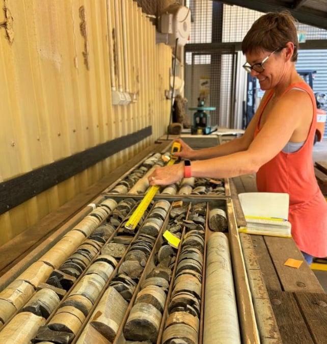 Un ricercatore misura carote di roccia cilindriche conservate in vassoi presso il magazzino del Northern Territory Geological Survey a Darwin, Australia.