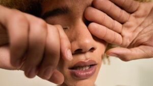 teen rubbing eyes