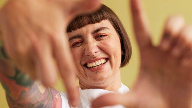 Ritratto di una donna allegra che fa un'inquadratura con le dita