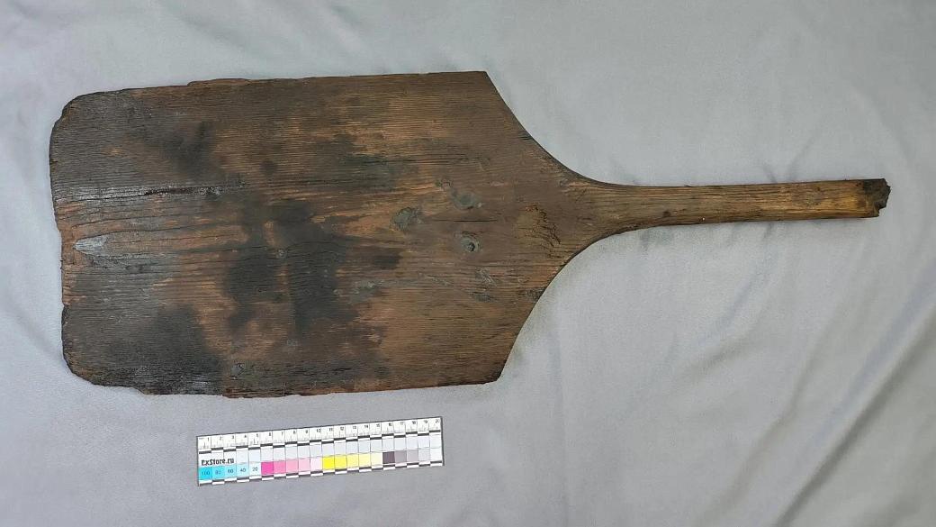 None una pala di legno piatta e rettangolare con il manico spezzato
