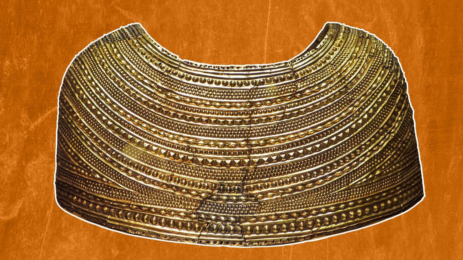 un accessorio d’oro simile a un mantello su sfondo arancione