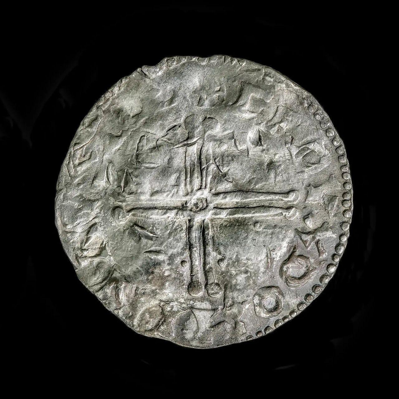 Primo piano di una moneta d’argento con una croce