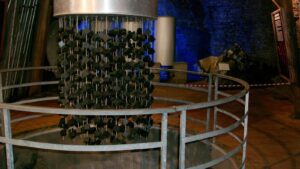 Primo piano di un reattore nucleare dietro sbarre di metallo.